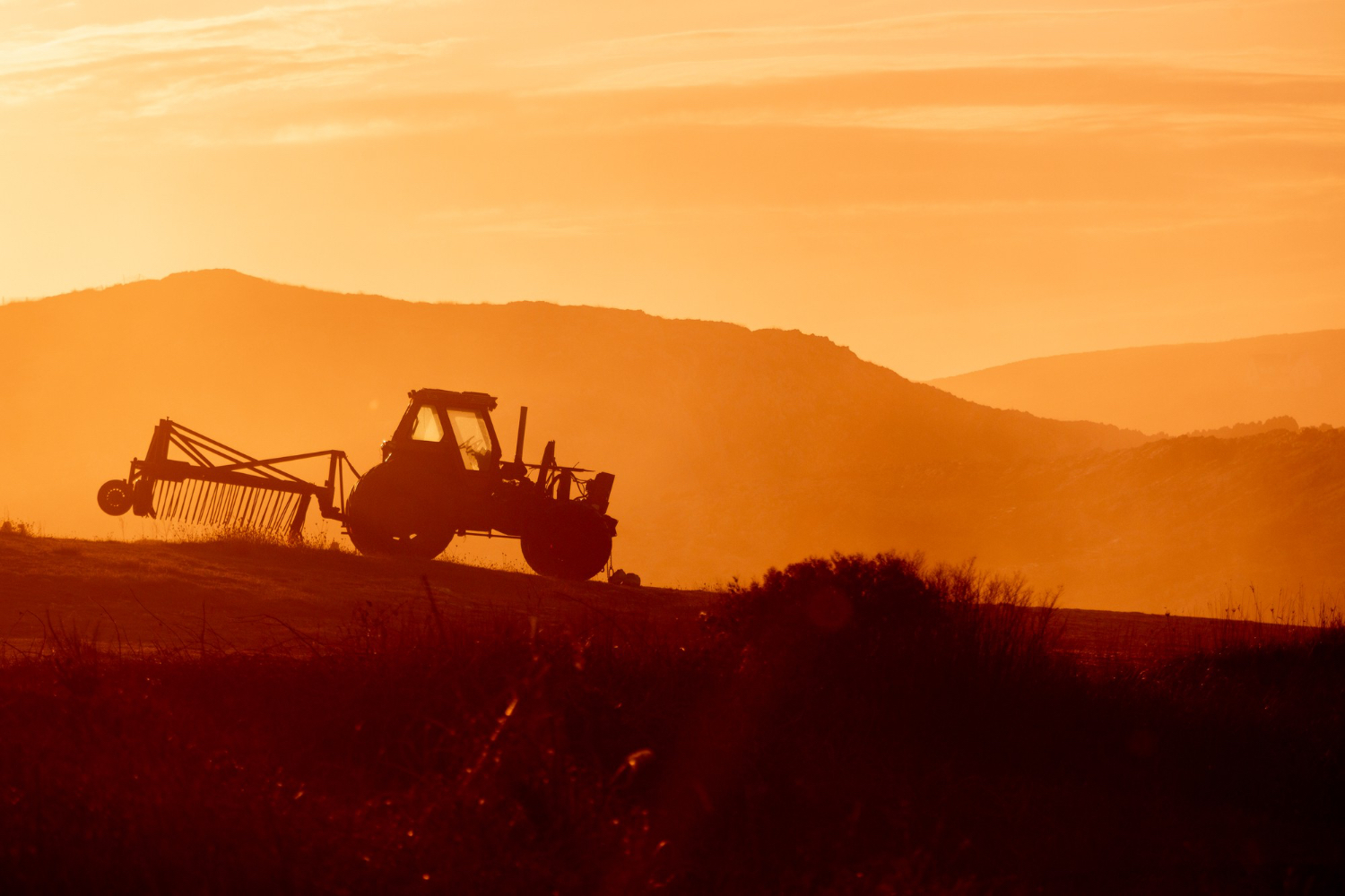Tracteur agricole au coucher du soleil