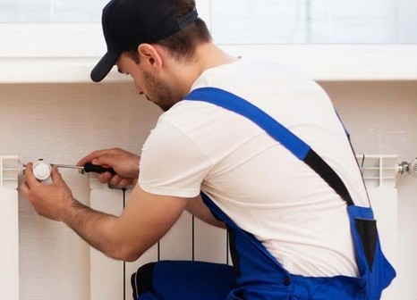 Technicien installant une tête thermostatique sur un radiateur